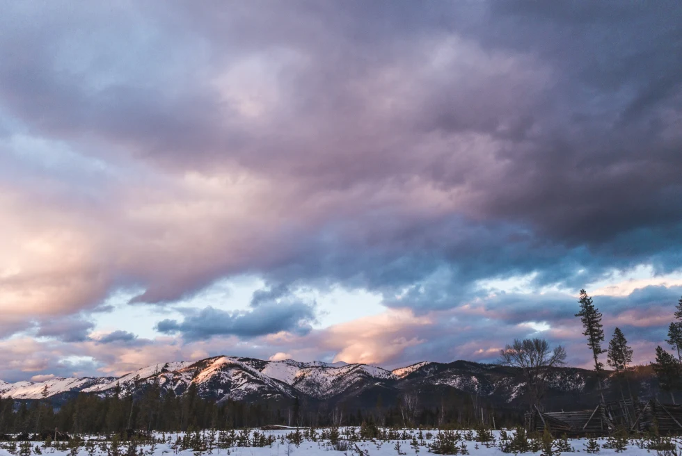 Pink and purple skies over snow-capped mountains during sunset