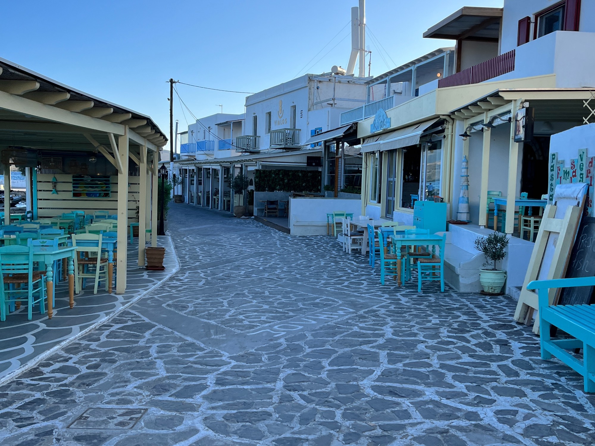 Light blue tables and chairs around a street. 
