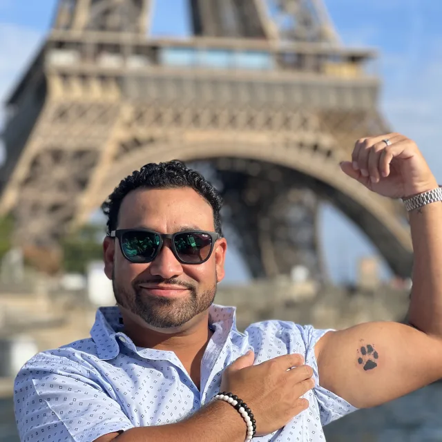 Irving Alvarado posing for a picture by the Eiffel Tower
