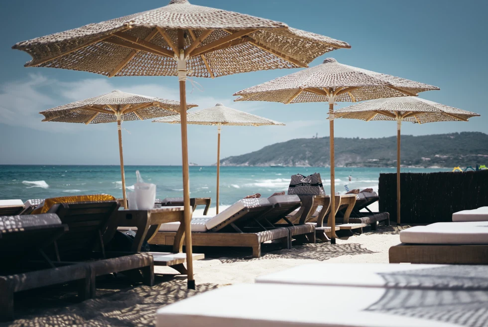 Brown wooden sunlounges on the beach