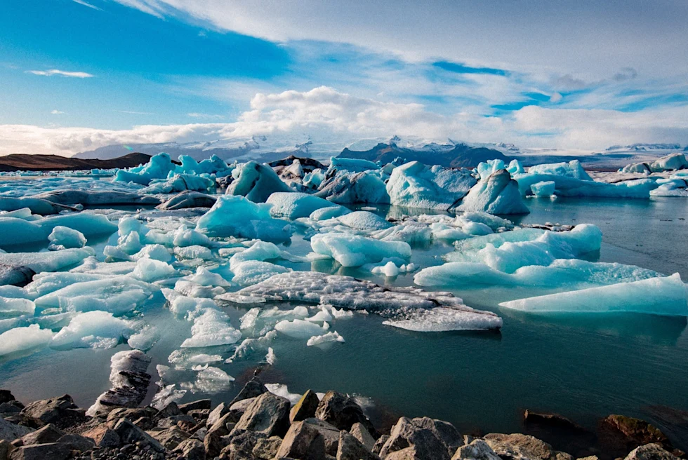 A blue lake with batches of snow and ice
