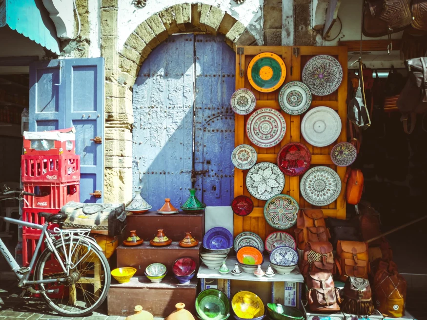 colorful wall and door covered with plates and a bicycle