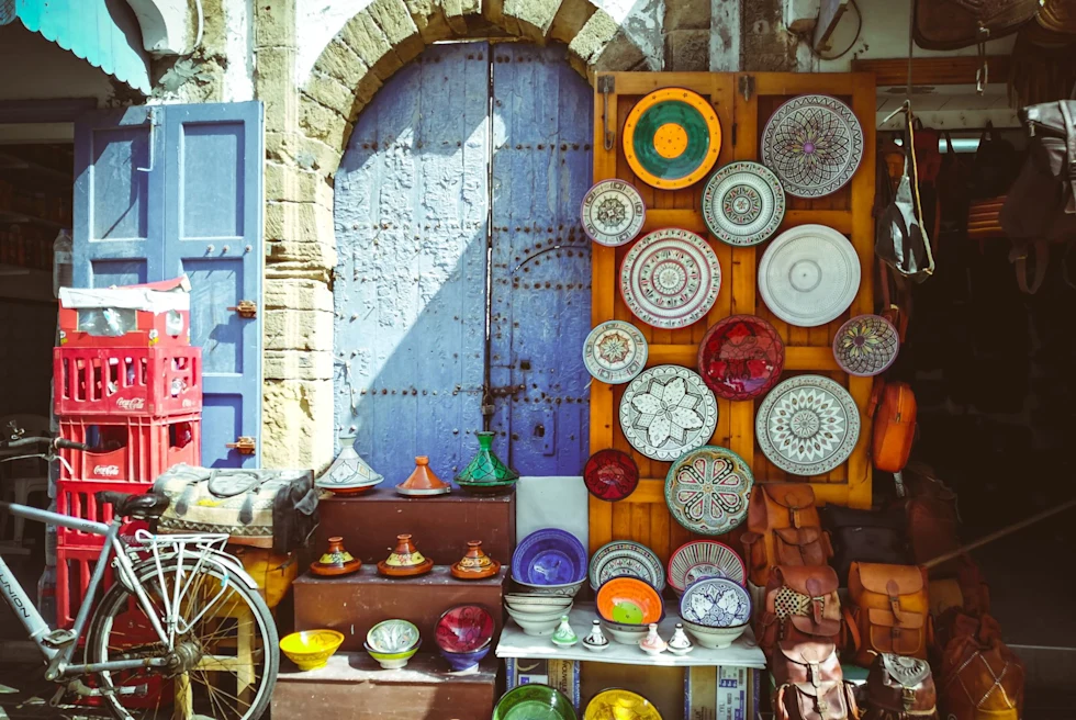 colorful wall and door covered with plates and a bicycle