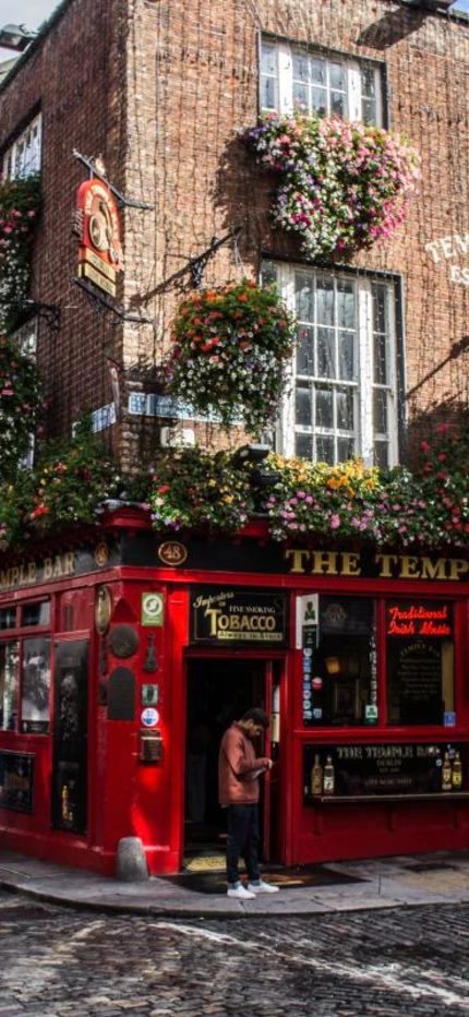 Classic Irish corner pub on cobblestone street in Dublin, Ireland on a sunny day. 