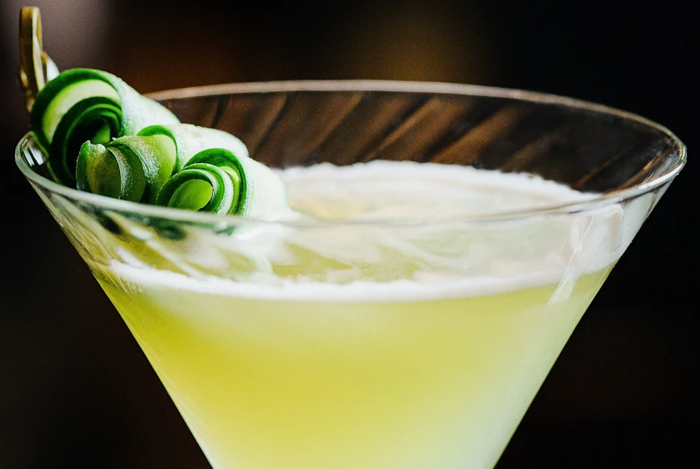 A light yellow cocktail in a goblet.