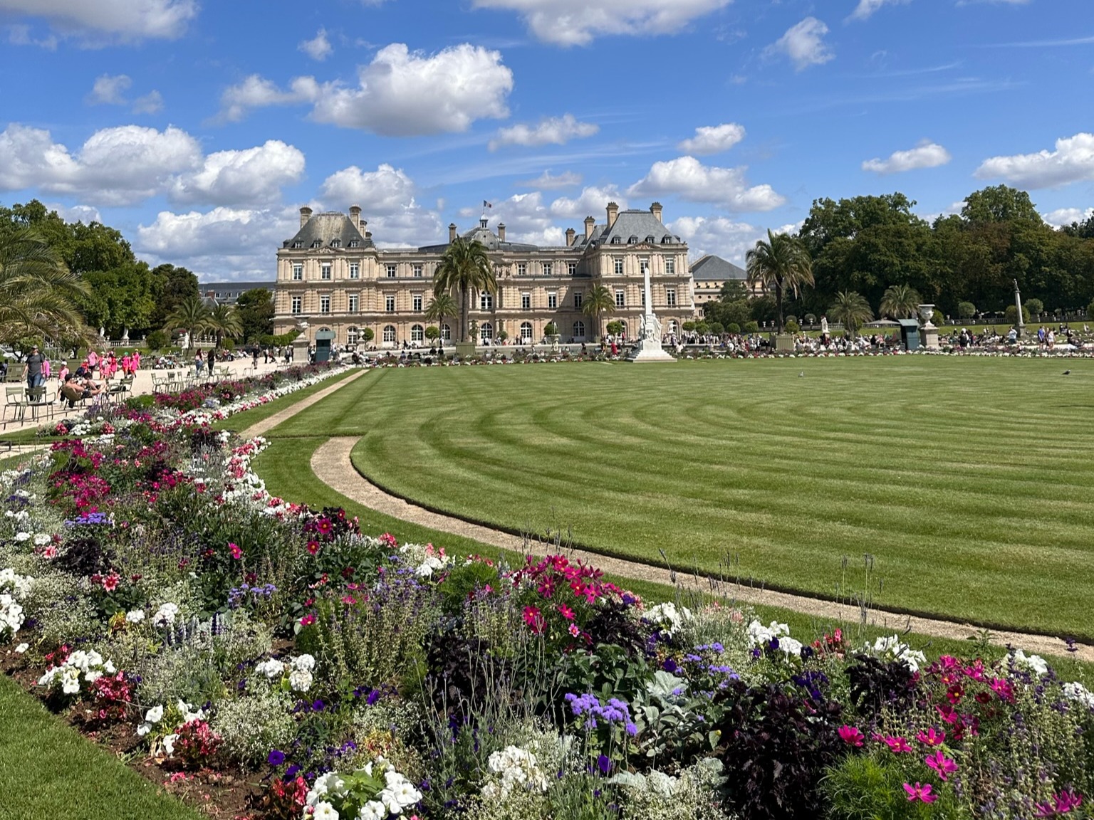 A green ground surrounded by colorful flowers. 