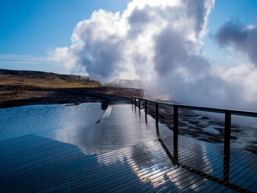 geothermal bath with wooden deck with steam rising from the water 