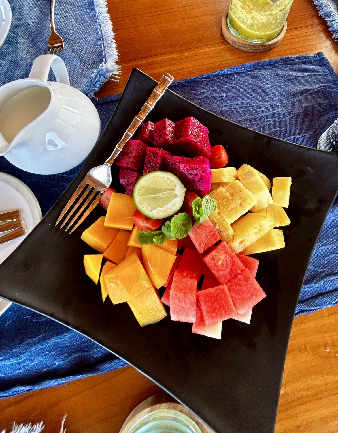 A plate of fresh fruit with a morning juice. 