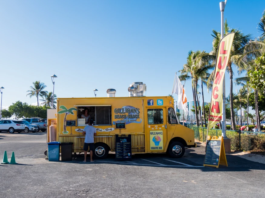 yellow food truck parked in a parking lot during daytime