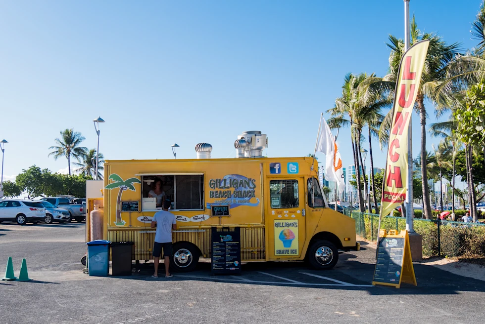 yellow food truck parked in a parking lot during daytime