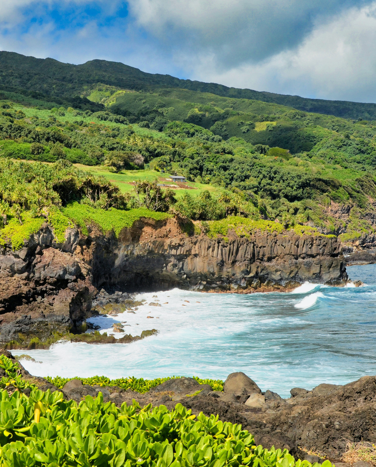 Body of water next to cliffs and green mountains during daytime