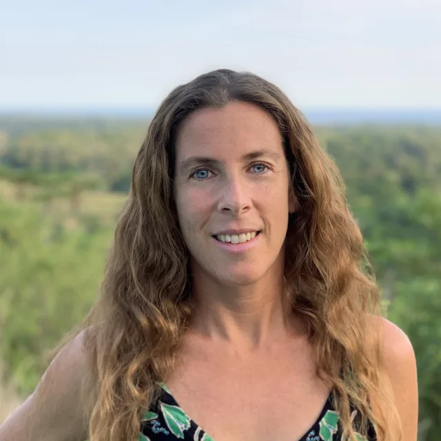 Travel advisor Claire Lipton wears a green tank top with green plants in the background