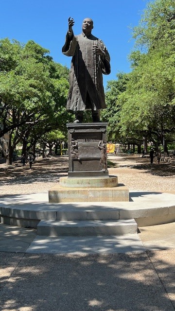 A statue of a man in the middle of a park during the daytime
