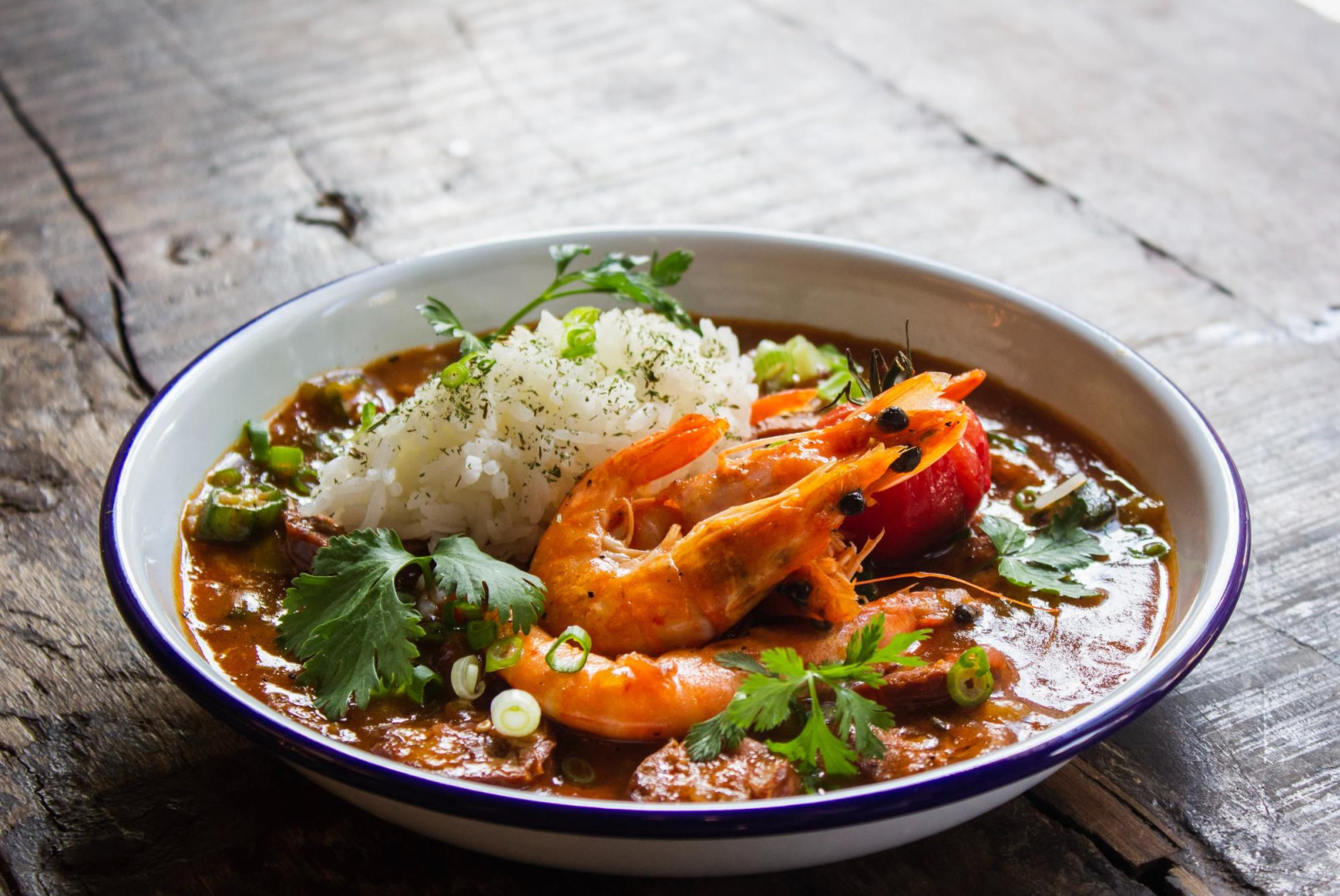 Red seafood stew with unpeeled shrimp and rice.