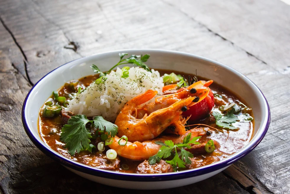 Red seafood stew with unpeeled shrimp and rice.