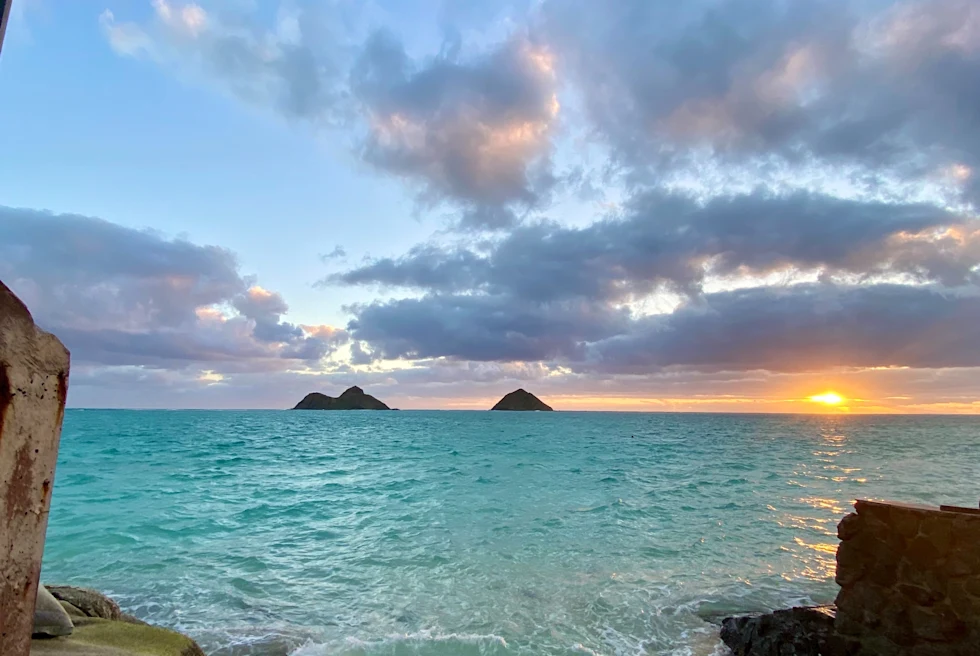 Body of water with mountains in the distance during sunset
