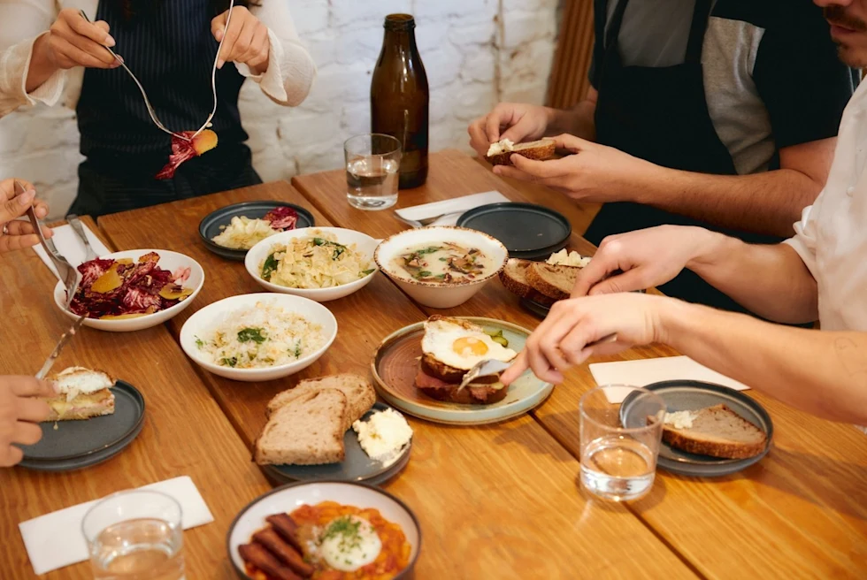 table covered with plates of bread and eggs