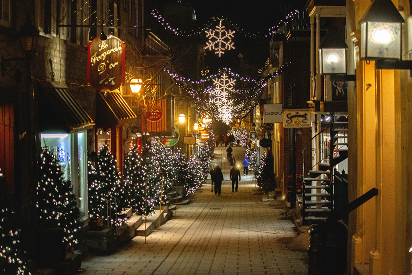 quebec city in Canada with holiday trees and lights in the cobblestone streets