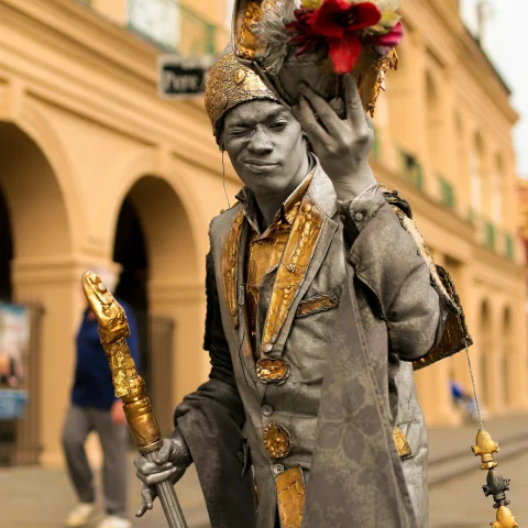 A person posing as a statue holding a bouquet of flowers