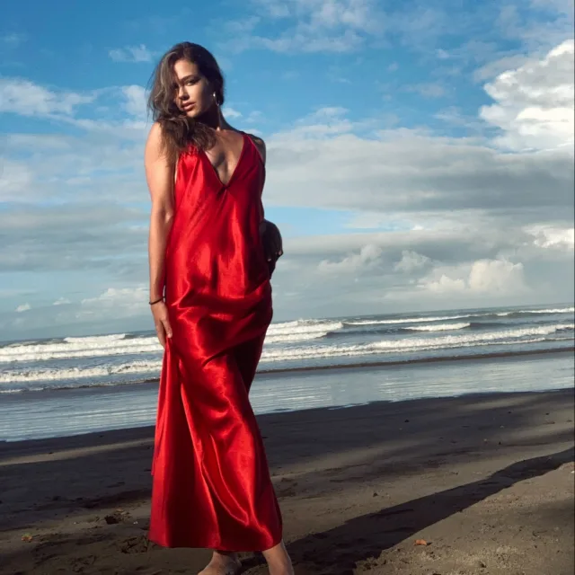 Travel Advisor Susanna M Keating in a red dress on a beach.