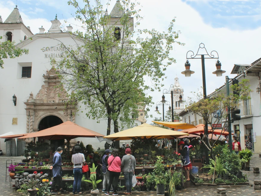 A street restaurant and people waiting around in Cuenca. 
