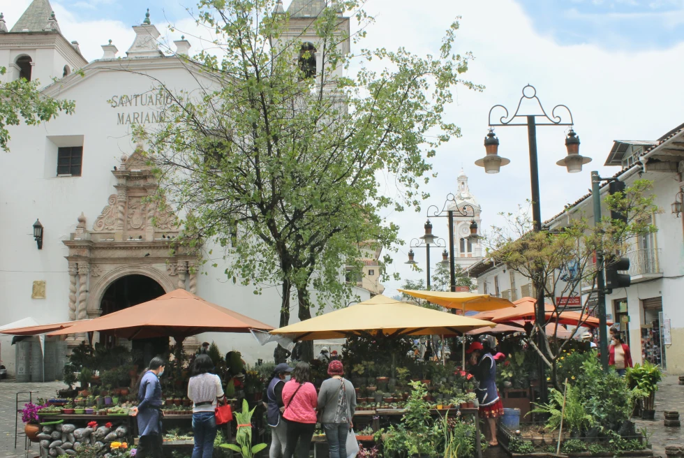 A street restaurant and people waiting around in Cuenca. 