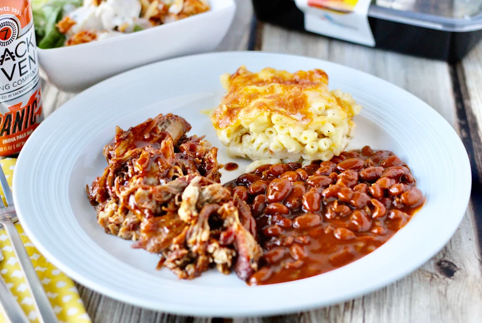 A plate with Southern comfort food including beans, mac-n-cheese and meat.
