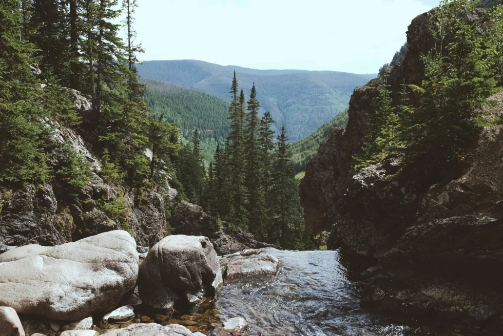 alpine river between two rocks overlooking a forested valley