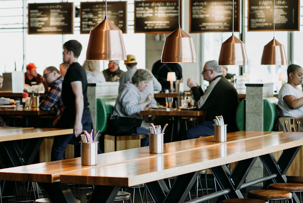 Inside of a restaurant with an elderly couple sitting.