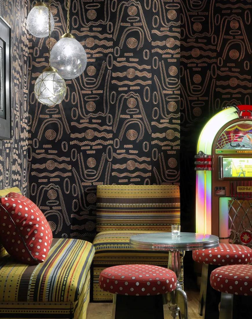 an old-fashioned juke box in a room with patterned wallpaper