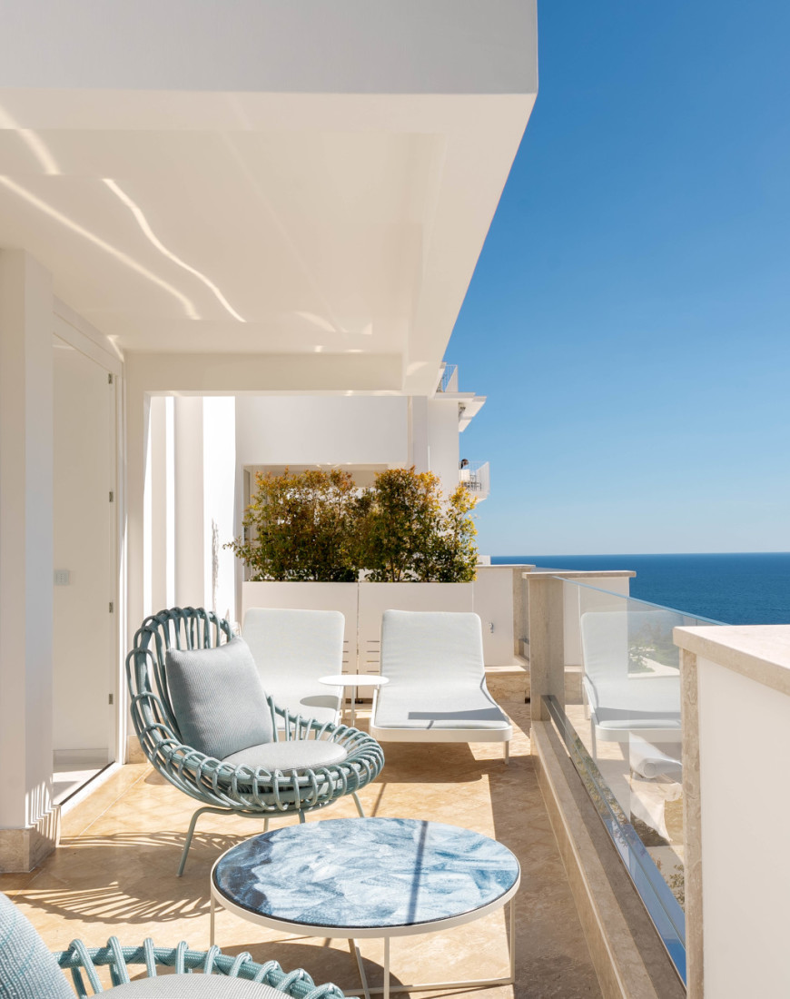 blue chairs on a white oceanside terrace