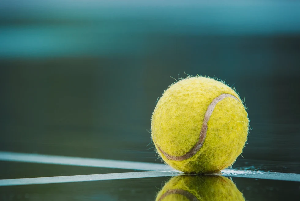 Yellowt ennis ball reflecting on tennis court in Jamaica