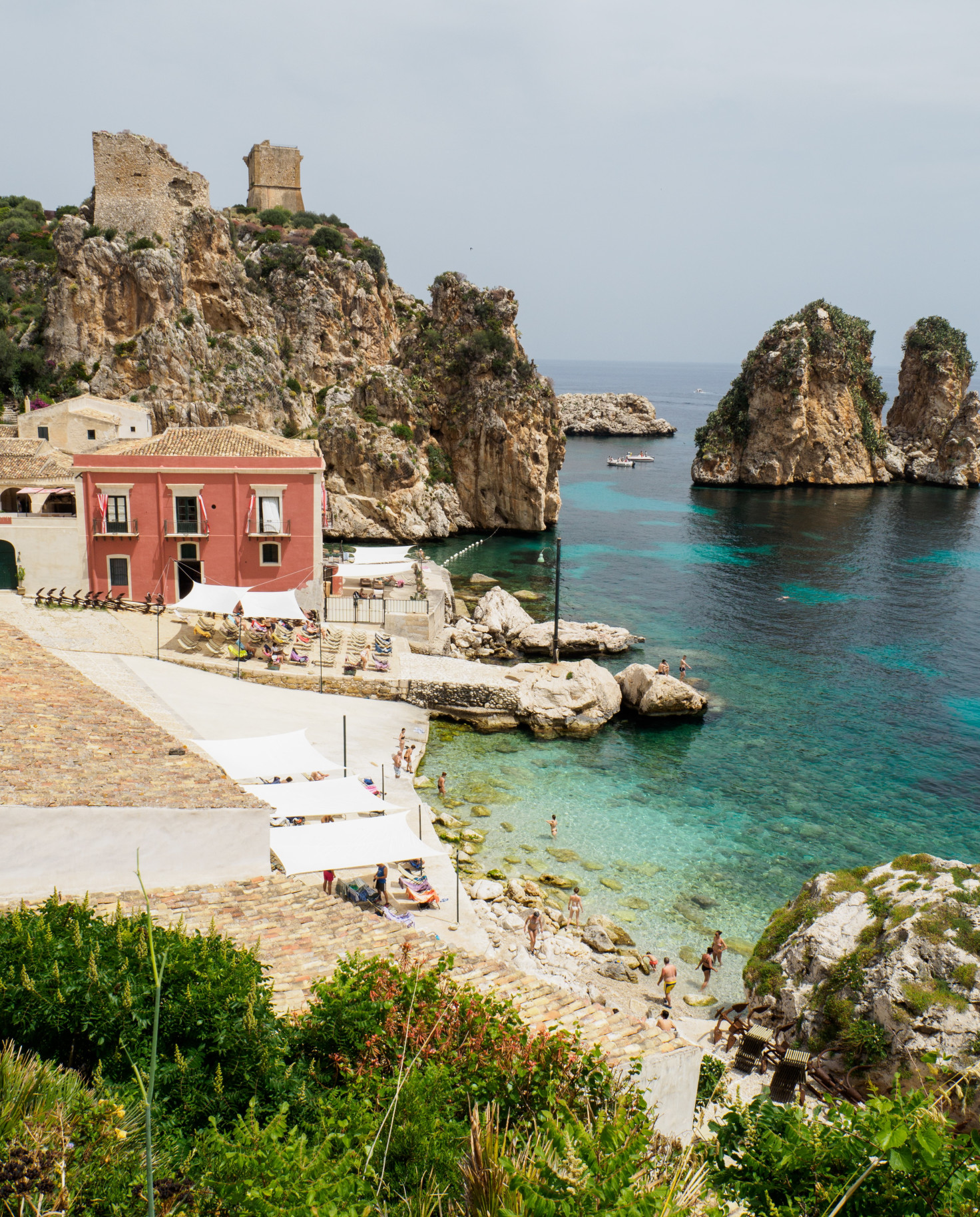 body of water next to rocks and red building during daytime