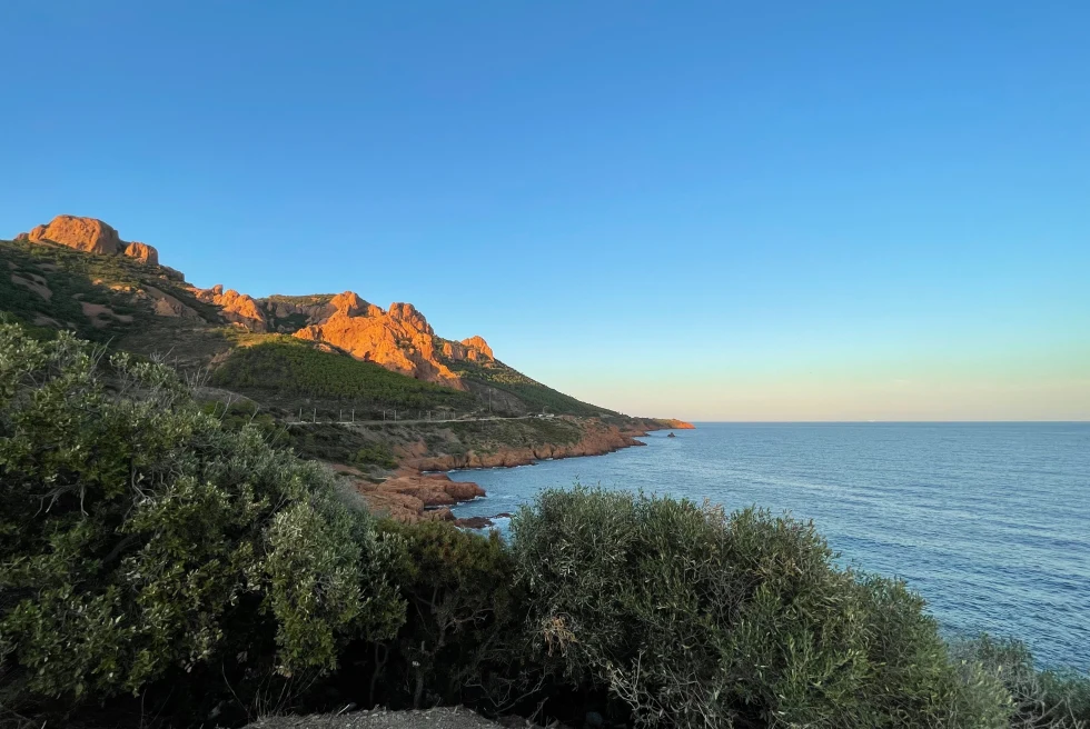 cliff next to body of water during sunset