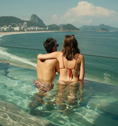 Couple posing in the pool looking into the ocean