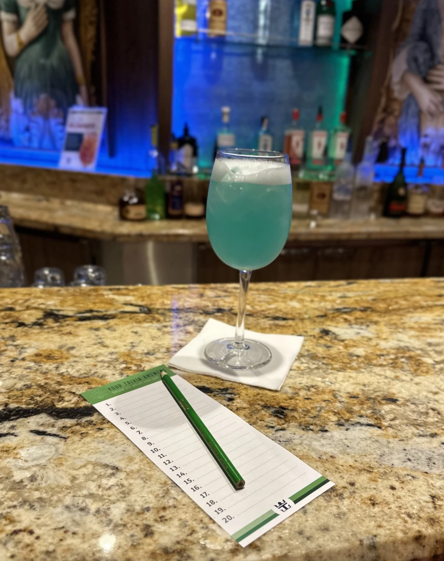 A blue drink in a wine glass at a bar