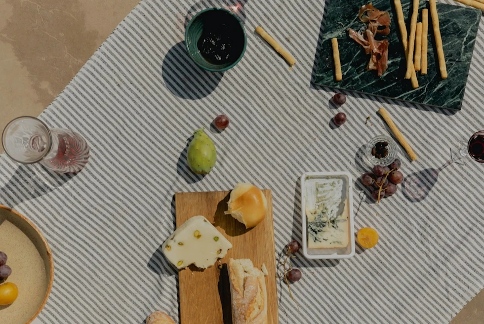 aerial view of a picnic of cheese, meats, and bread