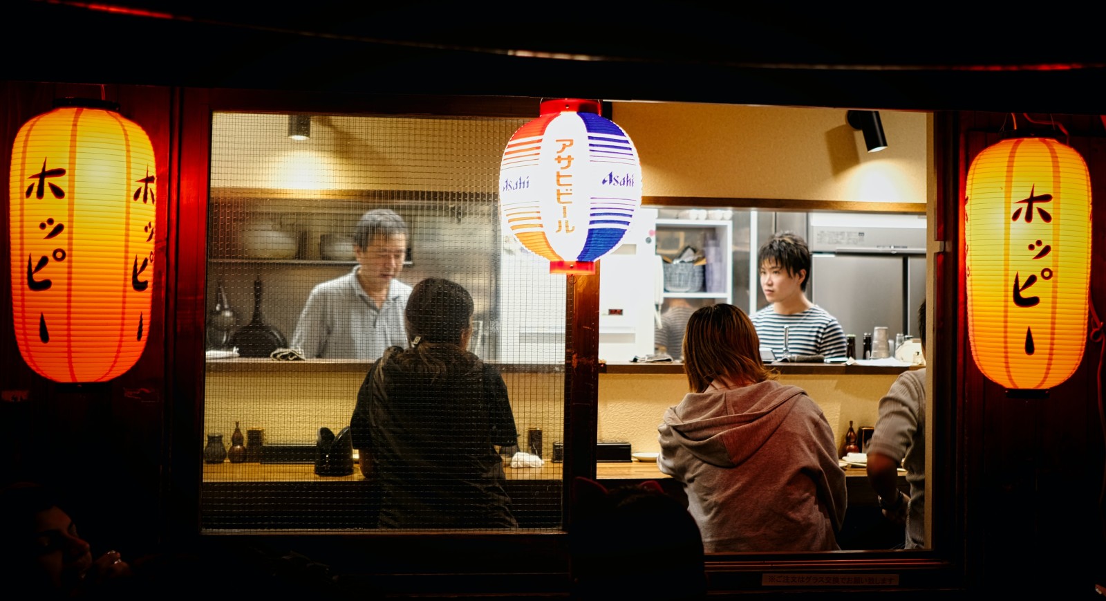 people sitting at a bar during nighttime