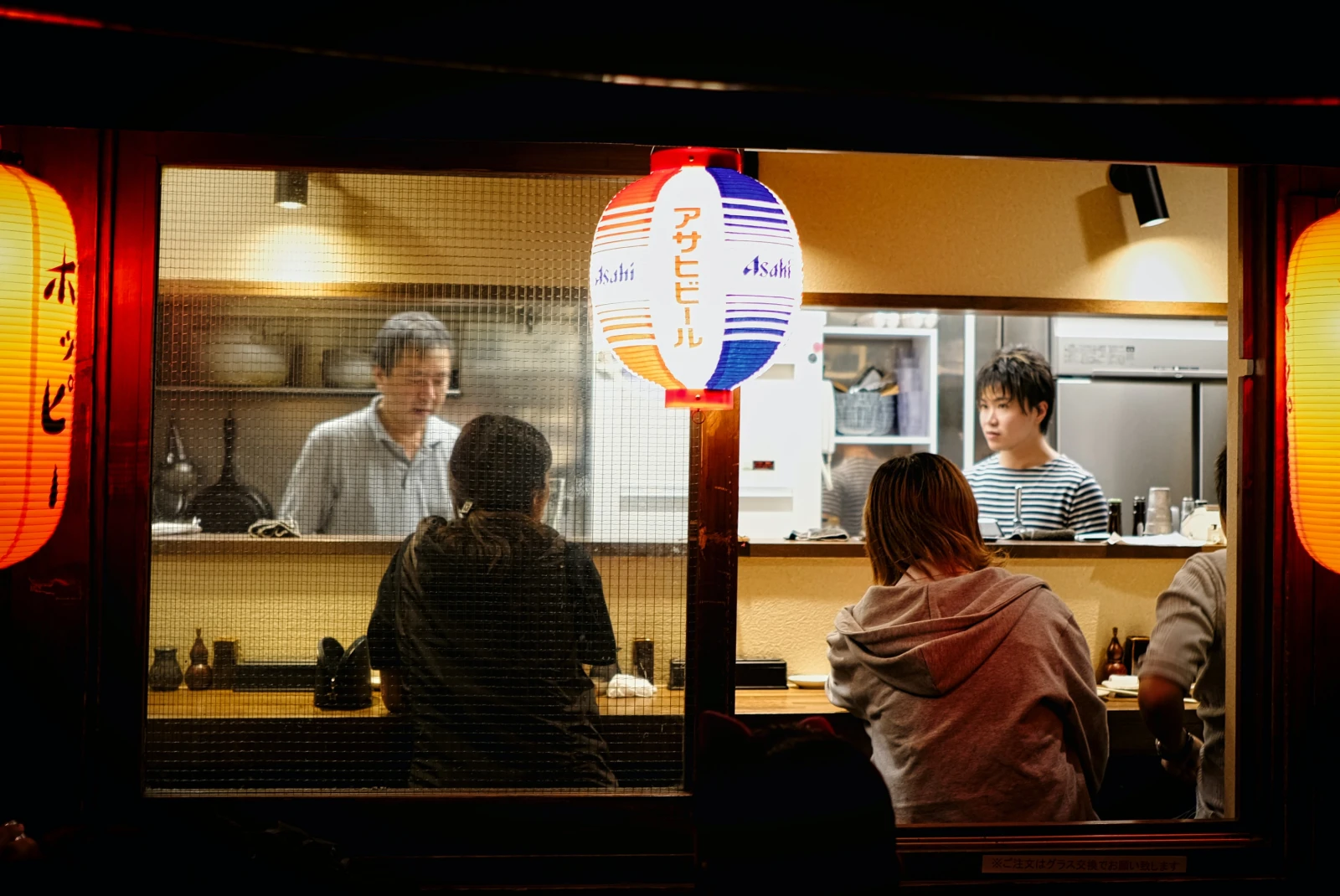 people sitting at a bar during nighttime