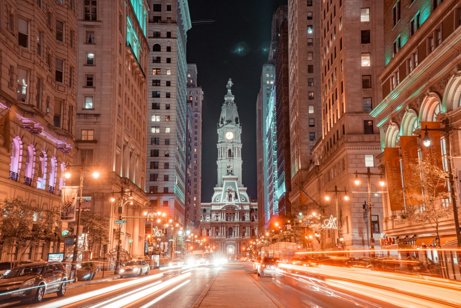 Long exposure shot of street in downtown Philly at night with buildings lightened streetlights and car headlights.