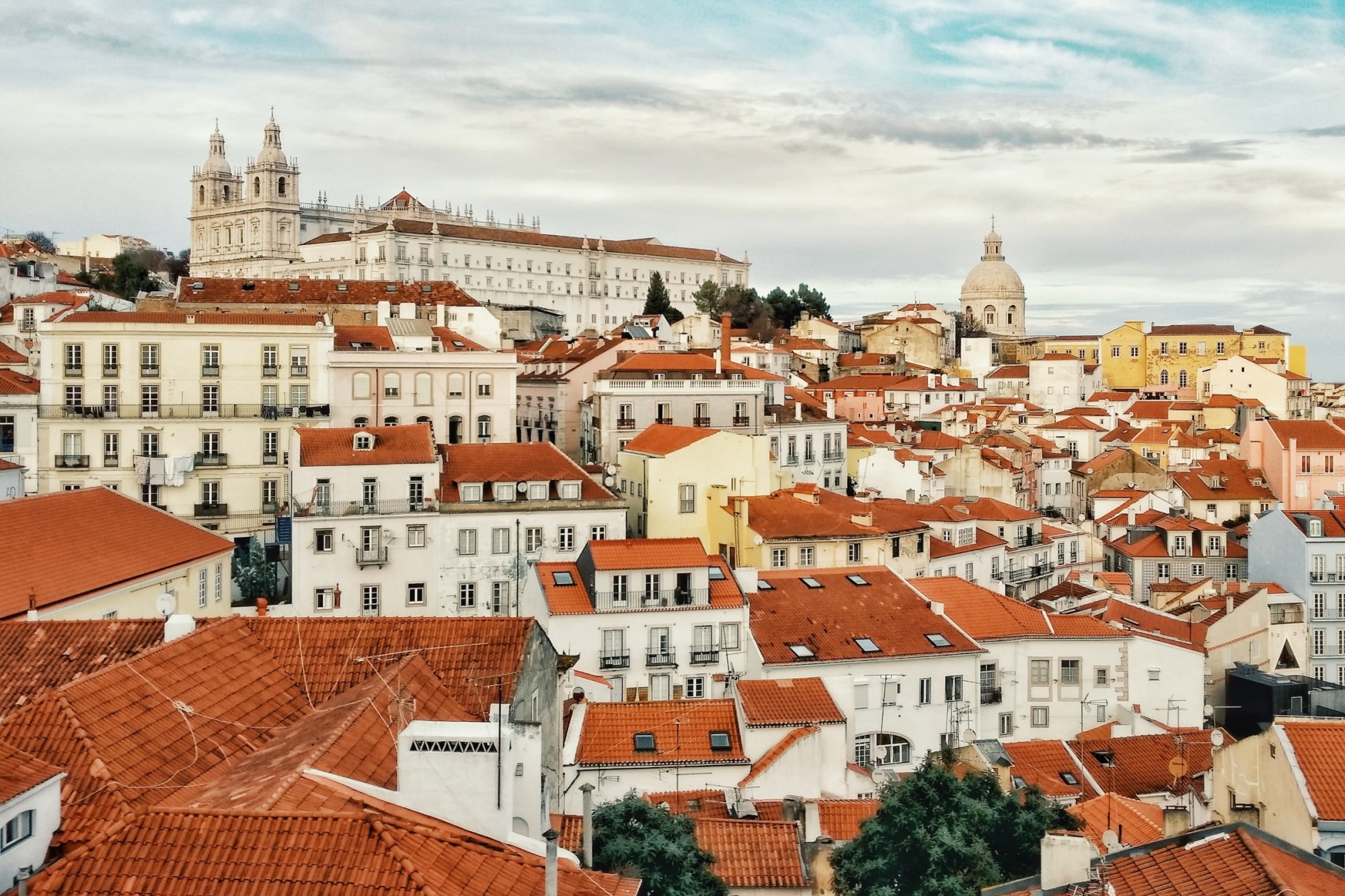 Orange-tile roofs and whitewashed buildings fill narrow streets in Alfama, Lisbon