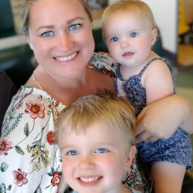 Travel Advisor Cortney Taylor in a floral shirt with her two babies.