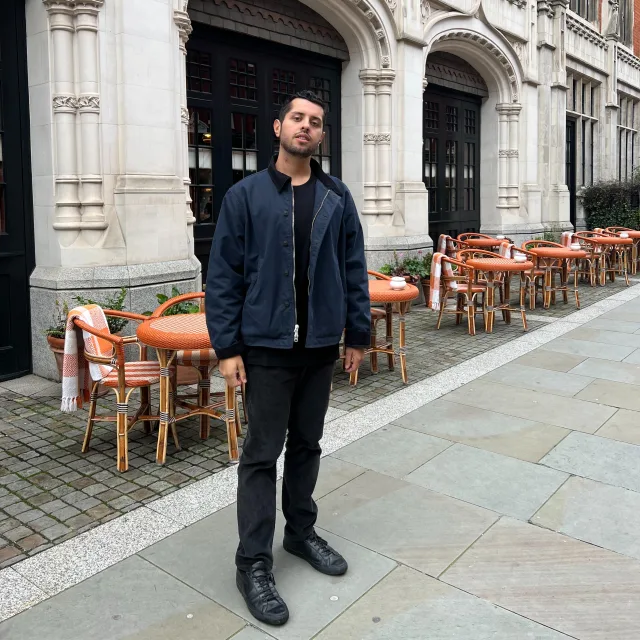 Travel advisor standing in front of a restaurant wearing black