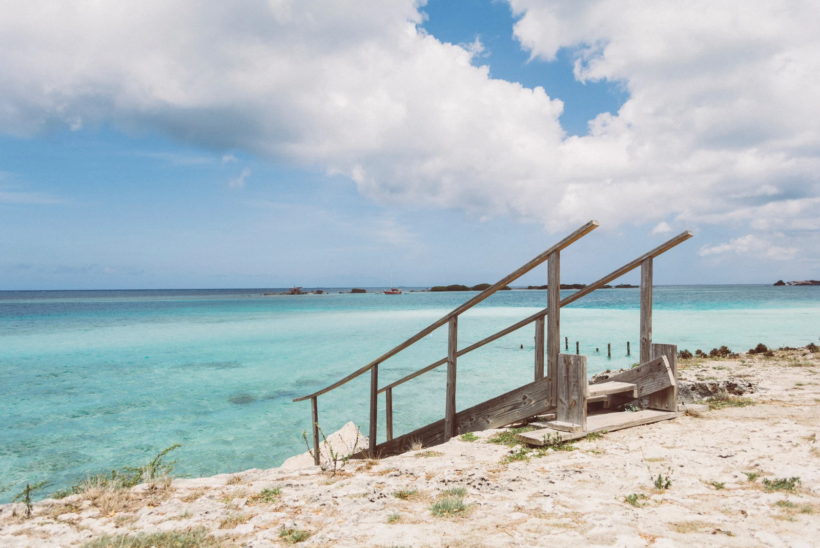 Stairs leading down to bright blue waters in Aruba