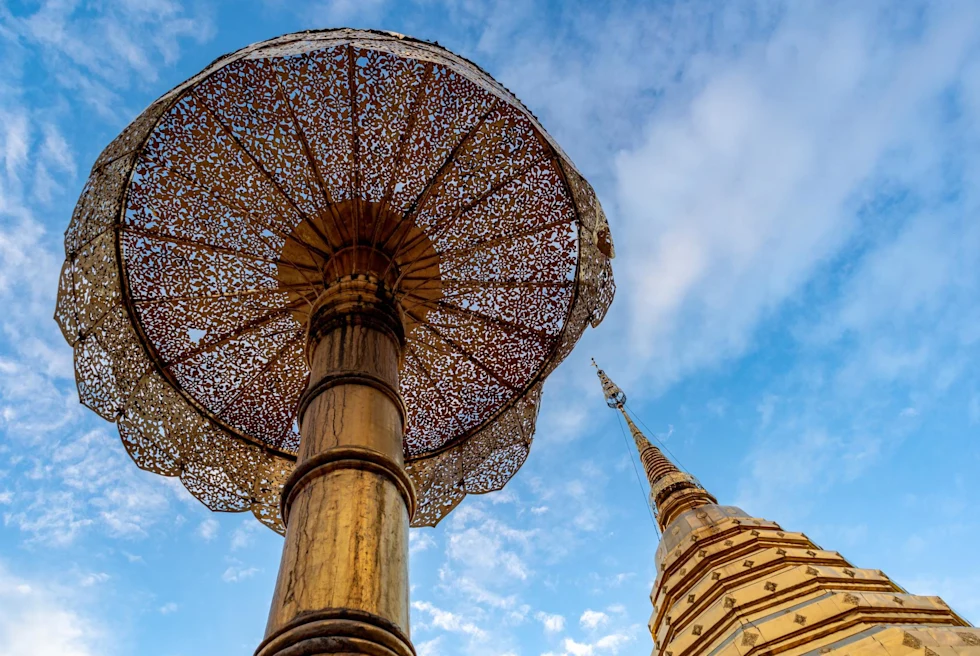 view from below of ornate temple spire and umbrella shaped feature