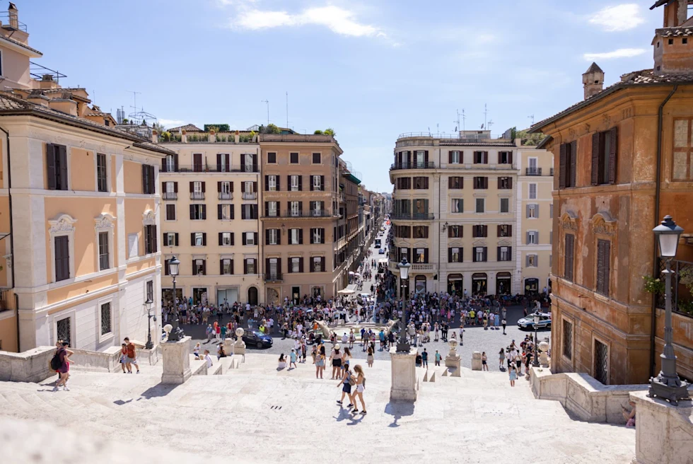 view from the tops of a shallow set of stairs that lead to a bustling old city