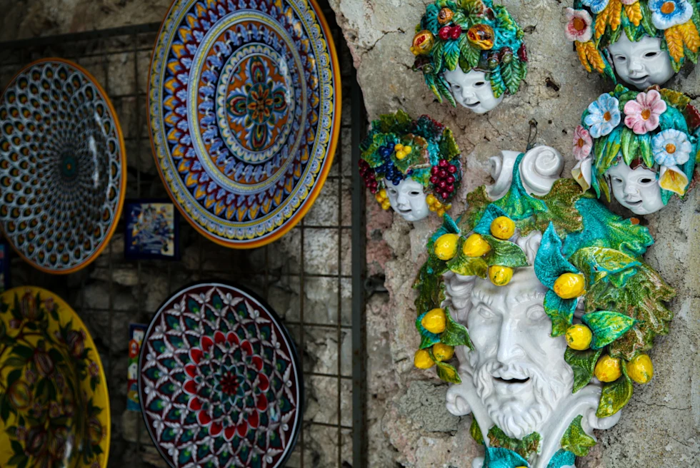 Amalfi coast souvenirs hanging on a wall in a store.