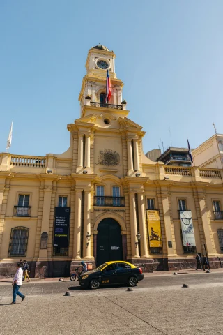 The exterior of the Museum of National History of Chile in Santiago, Chile, a yellow building with a tall central tower.