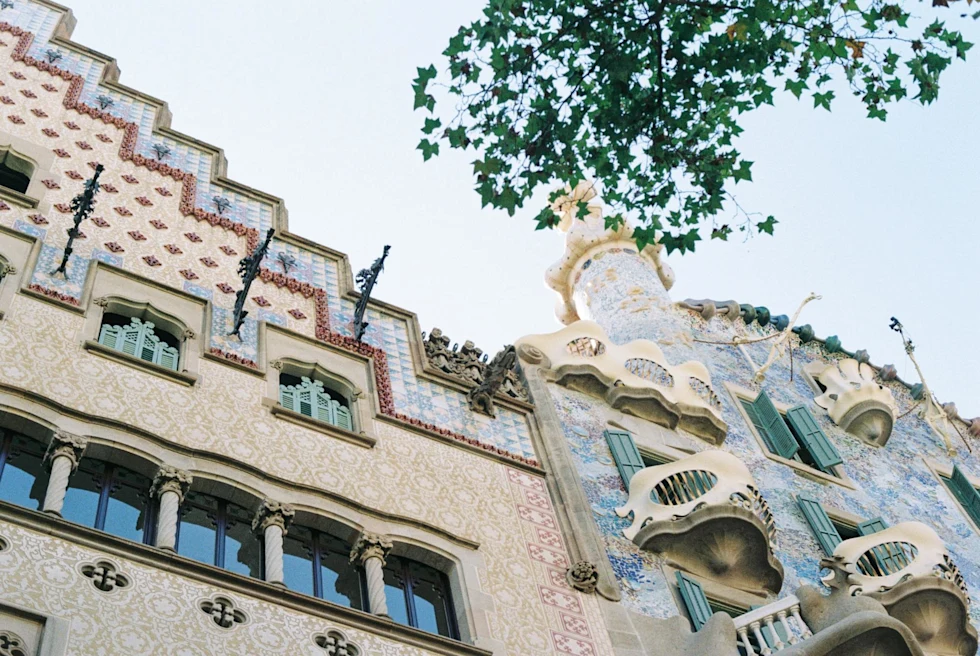 looking up an an ornate facade of a 2 buildings designed with tile and balconies