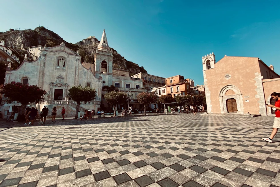 a center square with black and white checkered tile floors and a stone church 